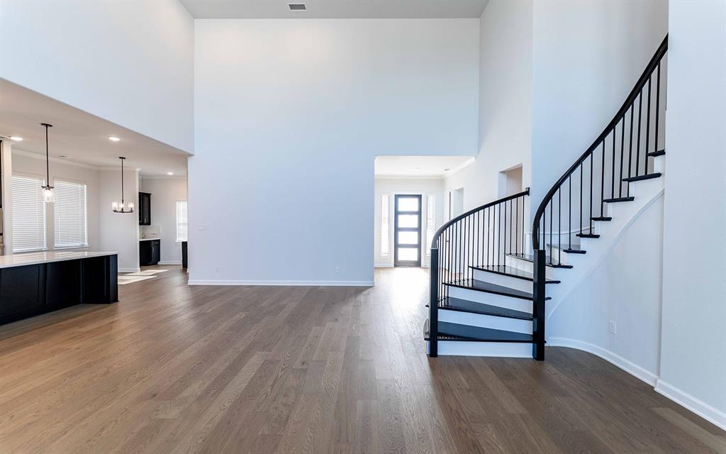 1916 Casting Ridge Mesquite, TX 75181 - Photo 6 of 26 a view of an empty room with wooden floor and a kitchen