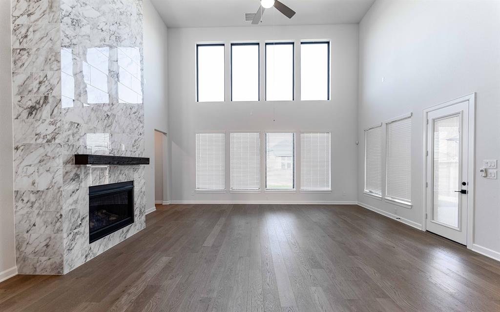 1916 Casting Ridge Mesquite, TX 75181 - Photo 7 of 26 an empty room with wooden floor fireplace and windows