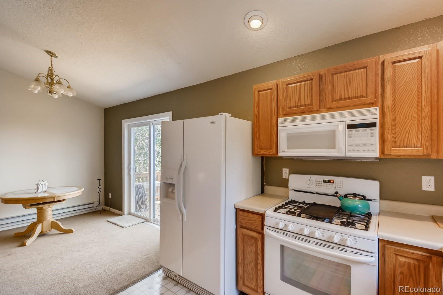 541 Paiute Road Evergreen, CO 80439 - Photo 9 of 22 a kitchen with a refrigerator a stove a washer dryer and cabinets