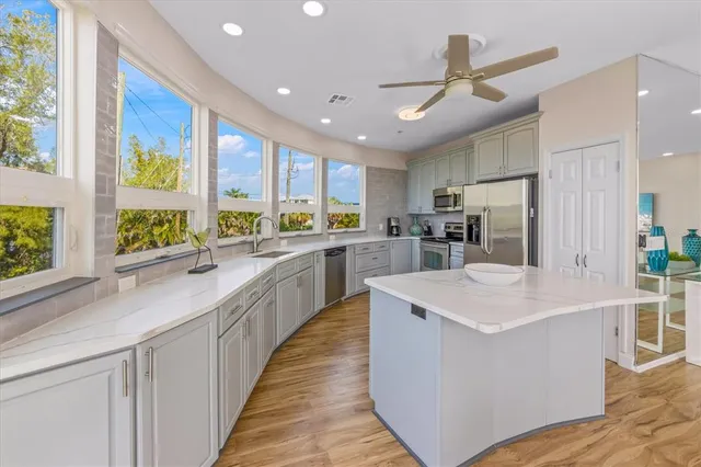 a bedroom with a bed painting on wall and a large window