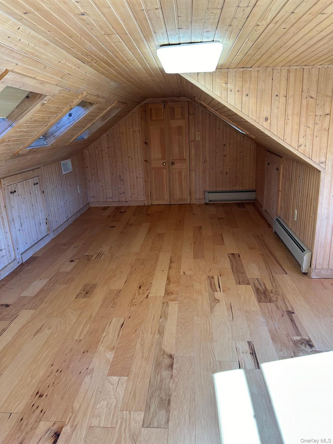 168 Pine Hill Road, Unit 1 Chester, NY 10918 - Photo 13 of 13 Bedroom with skylights and wood paneling and wood-style vinyl flooring