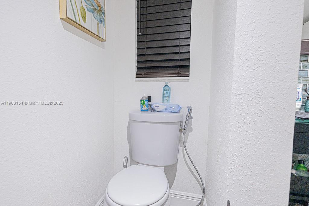 3450 Blue Lake Drive, Unit 305 Pompano Beach, FL 33064 - Photo 4 of 66 a white toilet sitting next to a bathroom sink