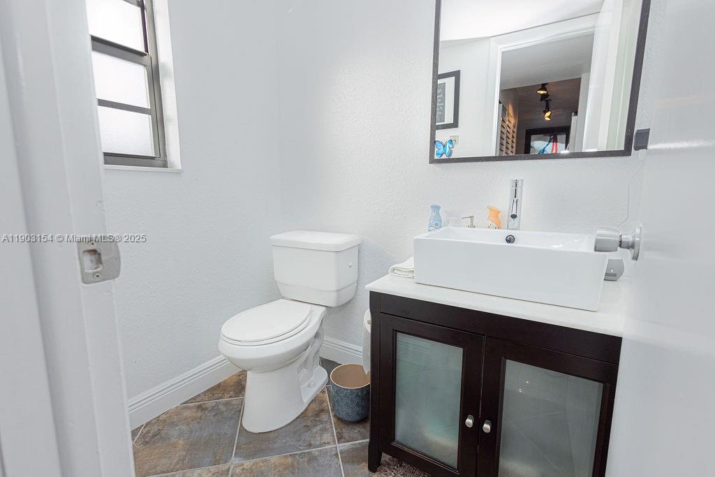 3450 Blue Lake Drive, Unit 305 Pompano Beach, FL 33064 - Photo 5 of 66 a bathroom with a sink toilet and mirror