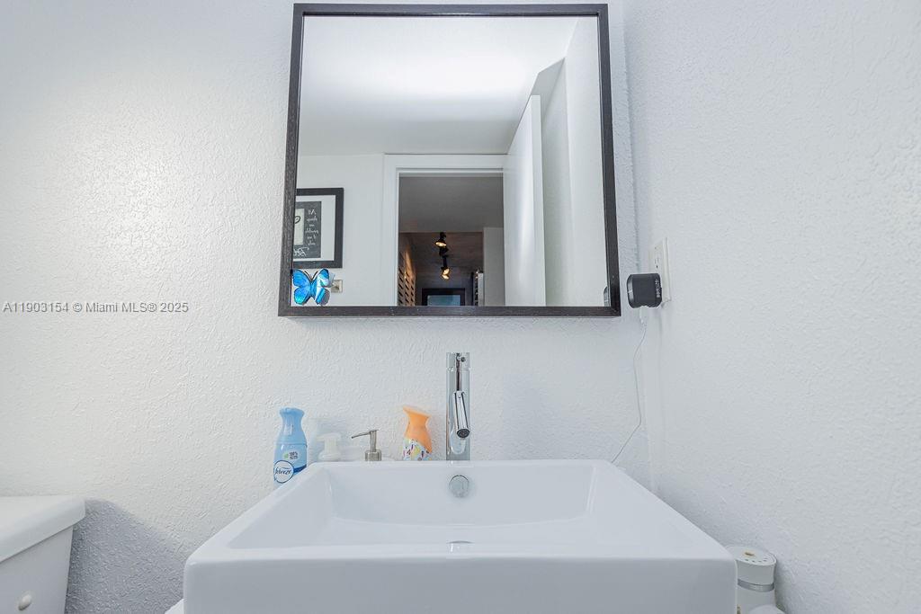 3450 Blue Lake Drive, Unit 305 Pompano Beach, FL 33064 - Photo 6 of 66 a bathroom with a sink and a mirror