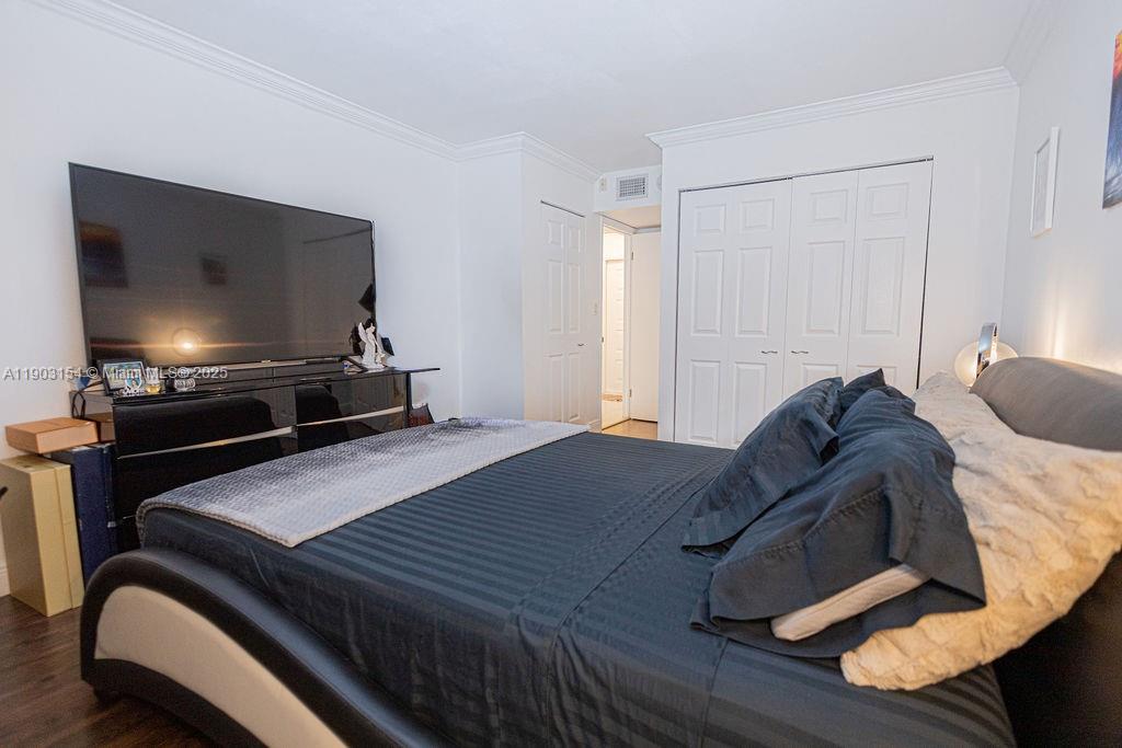 3450 Blue Lake Drive, Unit 305 Pompano Beach, FL 33064 - Photo 61 of 66 a bedroom with a bed and a flat screen tv