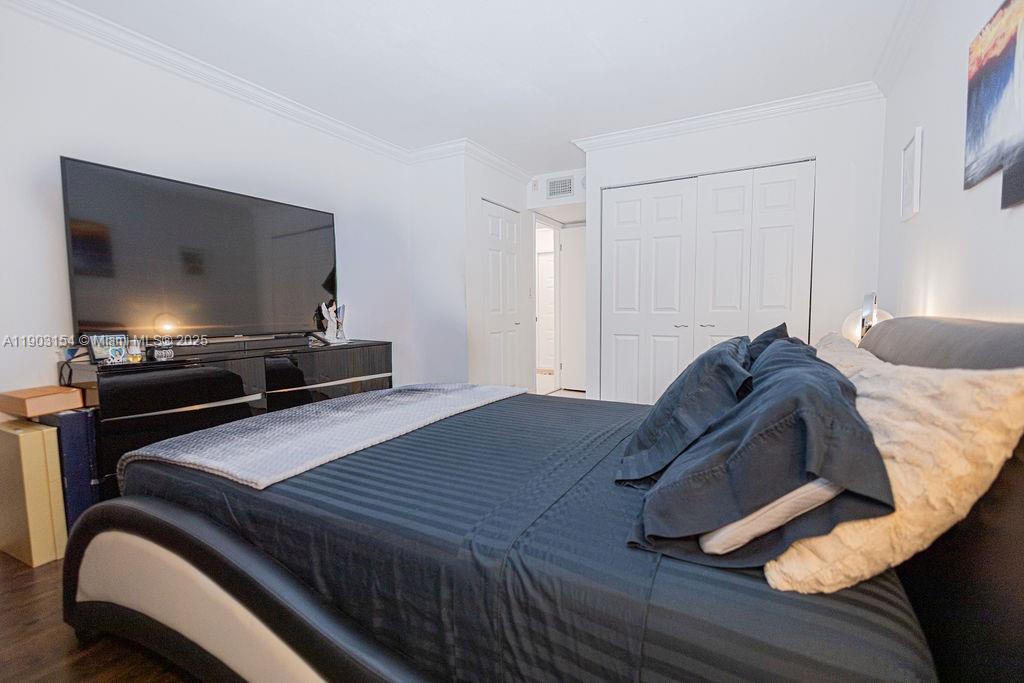 3450 Blue Lake Drive, Unit 305 Pompano Beach, FL 33064 - Photo 62 of 66 a bedroom with a bed and a flat screen tv