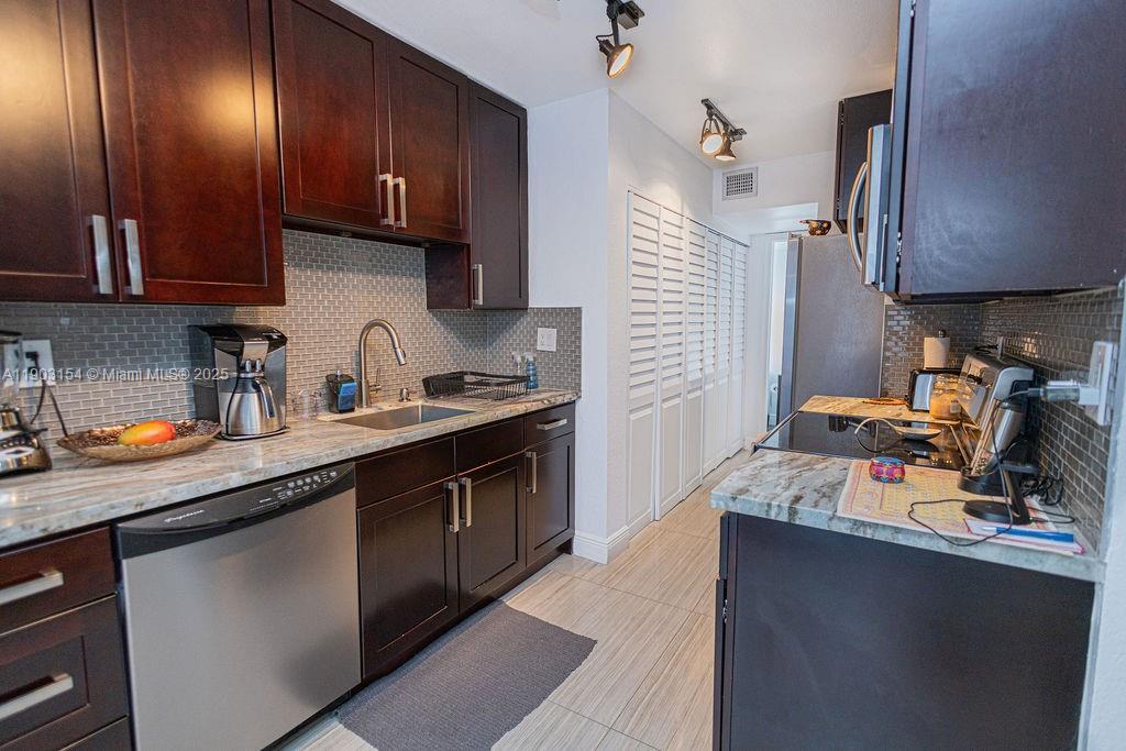 3450 Blue Lake Drive, Unit 305 Pompano Beach, FL 33064 - Photo 63 of 66 a kitchen with a sink cabinets and appliances