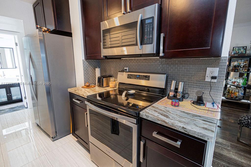3450 Blue Lake Drive, Unit 305 Pompano Beach, FL 33064 - Photo 65 of 66 a kitchen with stainless steel appliances and cabinets
