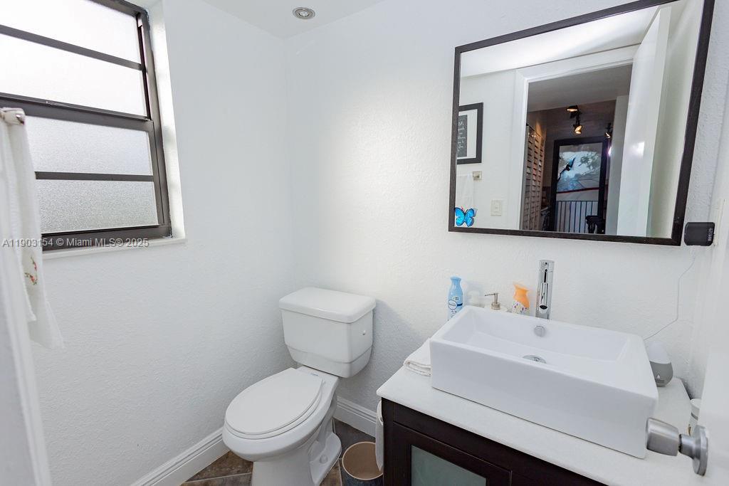 3450 Blue Lake Drive, Unit 305 Pompano Beach, FL 33064 - Photo 7 of 66 a white toilet sitting next to a bathroom sink