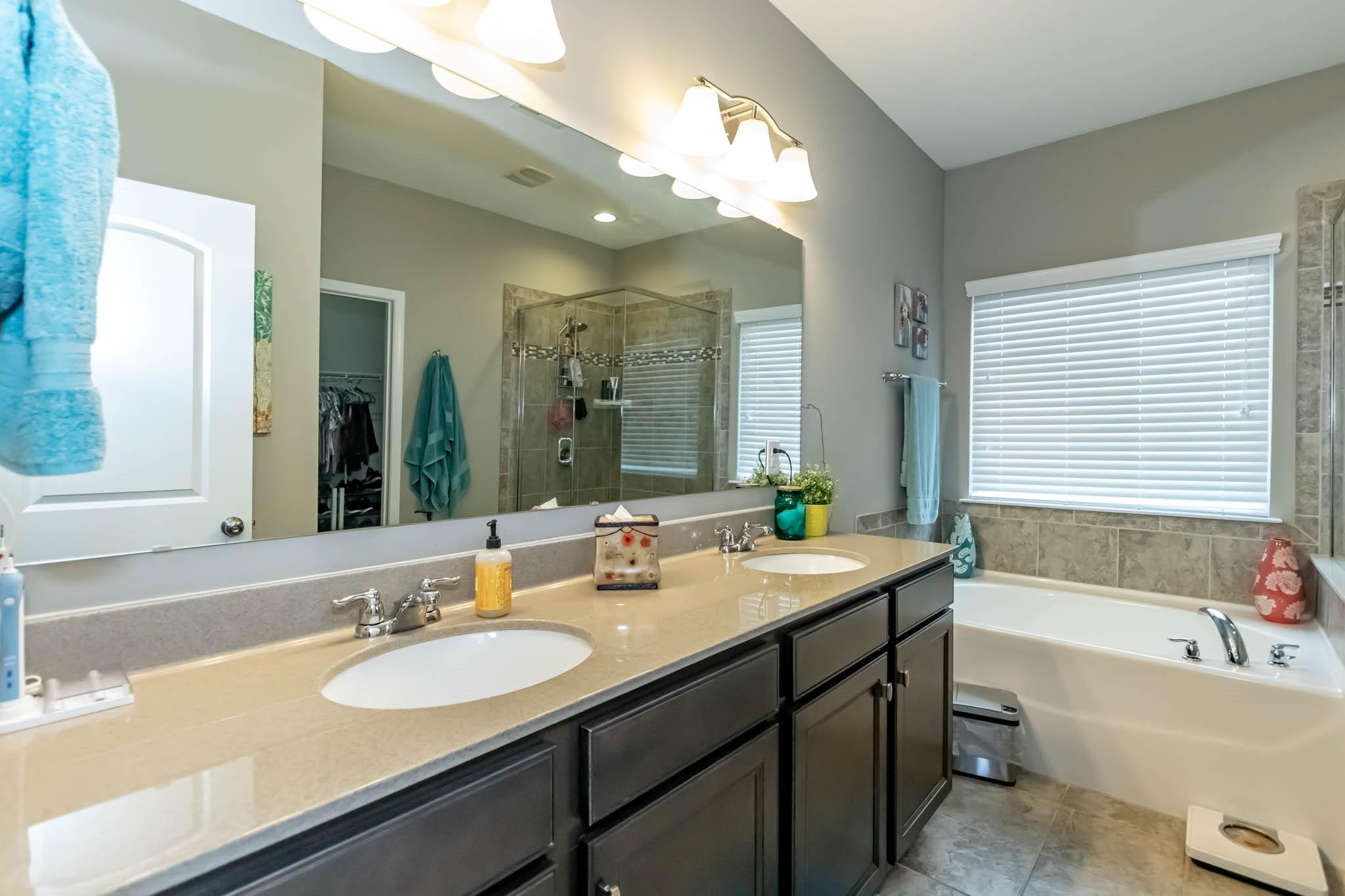 2984 Hiddenbrook Way Indian Land, SC 29707 - Photo 19 of 32 a bathroom with a sink double vanity granite tub shower and a mirror
