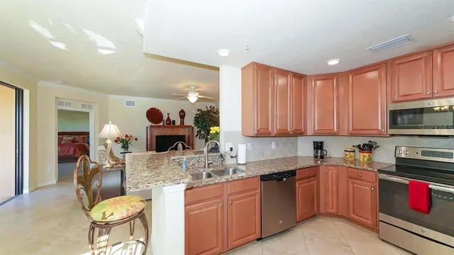 a kitchen with kitchen island granite countertop a sink cabinets and stainless steel appliances