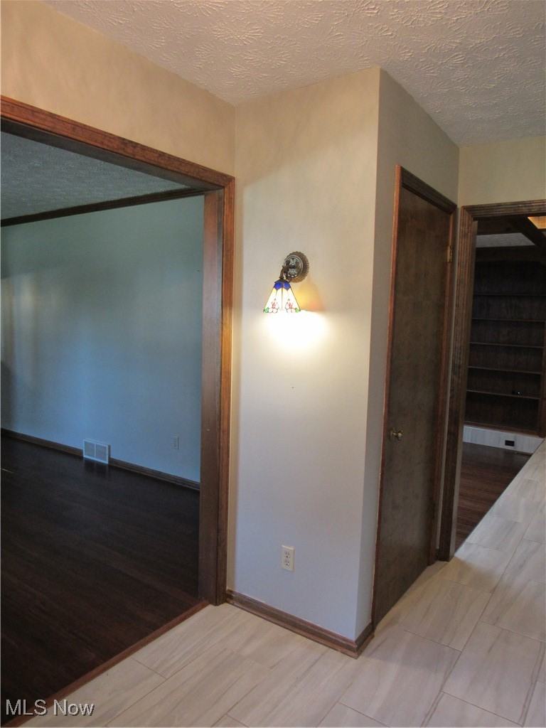 1120 Vincent Road Southeast North Canton, OH 44720 - Photo 7 of 50 Foyer textured ceiling, decorative wall light and Tile flooring