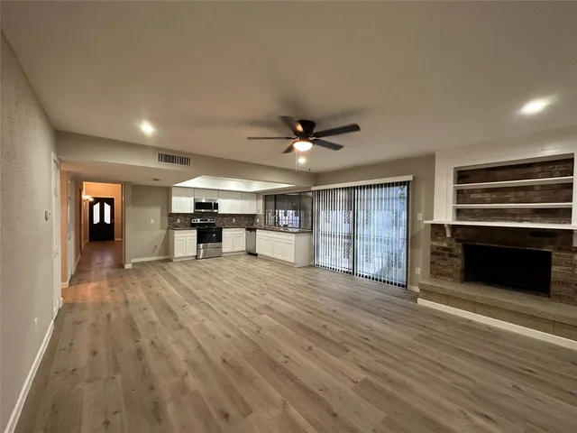 a view of an empty room with window and cabinet