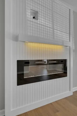 a view of empty room with wooden floor and window