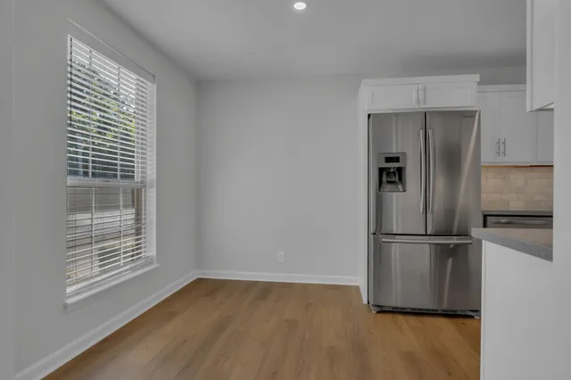 a kitchen with granite countertop white cabinets and stainless steel appliances