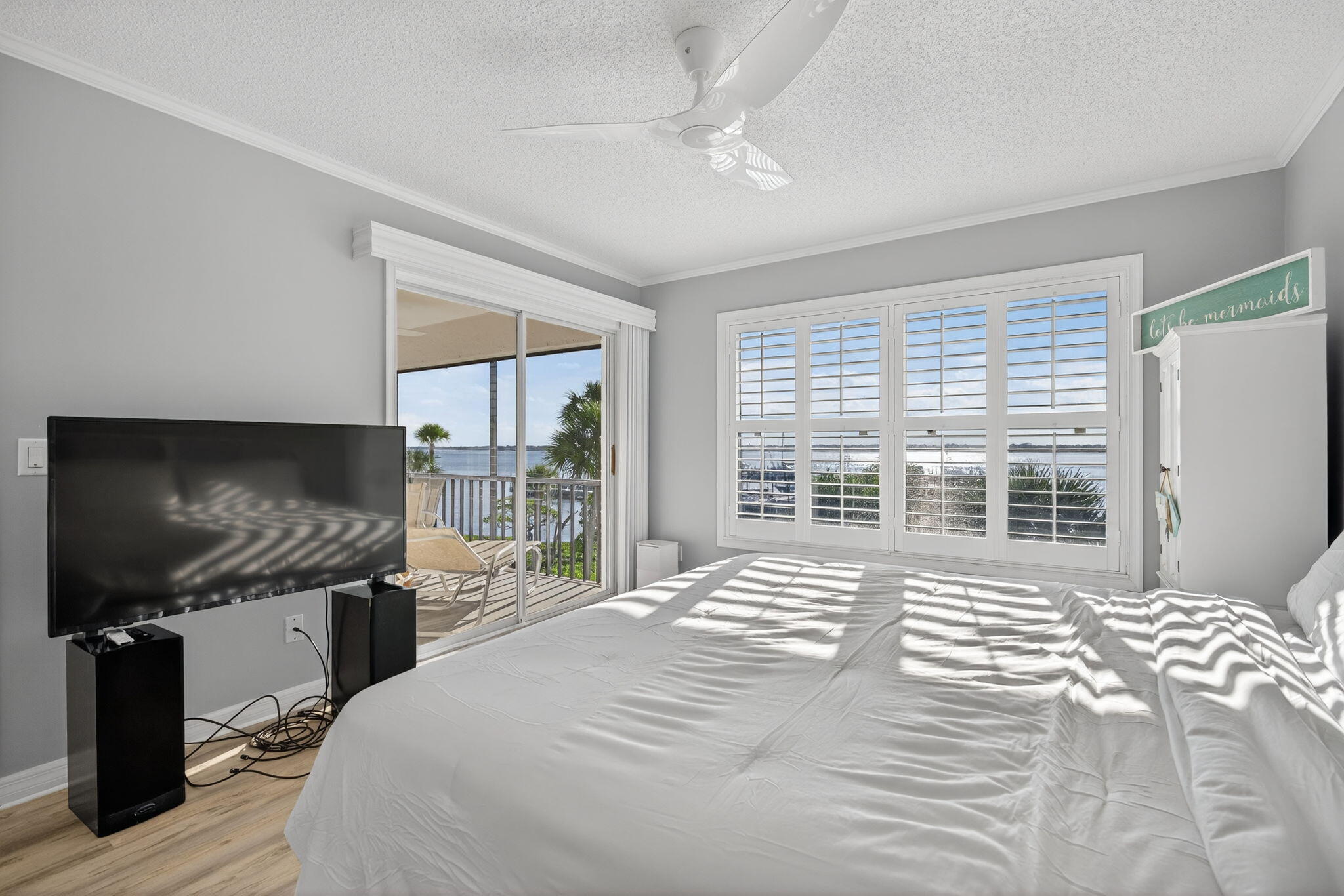 390 Northeast Edgewater Drive, Unit 403 Stuart, FL 34996 - Photo 15 of 46 a bedroom with a large bed and a flat tv screen