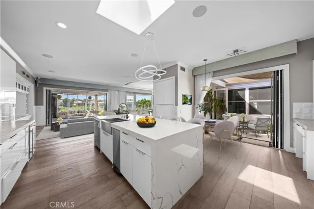 a view of kitchen with stainless steel appliances granite countertop a lot of counter top and living room