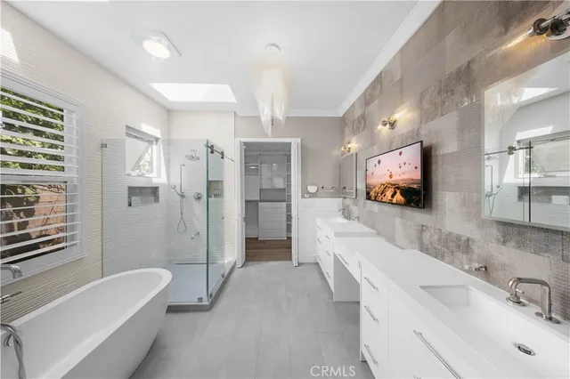 a bathroom with a bathtub a double vanity sink and mirror