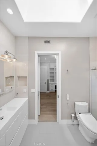 a bathroom with a granite countertop sink a toilet and shower