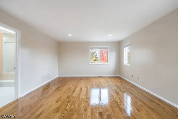 a view of an empty room with wooden floor