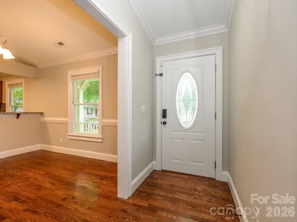an empty room with wooden floor cabinet and mirror