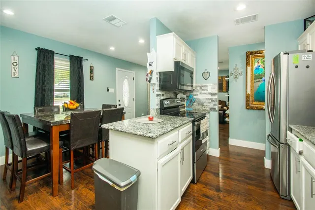 a kitchen with a table chairs refrigerator and furniture