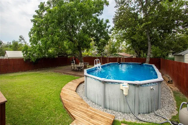 a view of a backyard with swimming pool