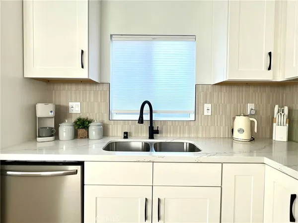 a kitchen with a stove and a white wooden cabinets