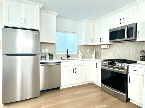 a kitchen with cabinets stainless steel appliances a sink and a microwave