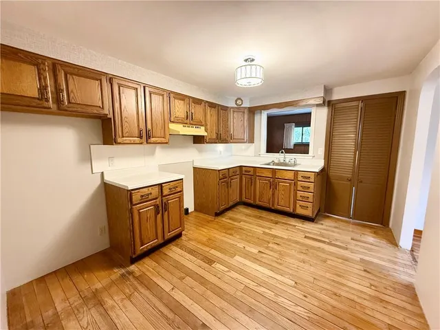 a kitchen with stainless steel appliances granite countertop a sink cabinets and wooden floor