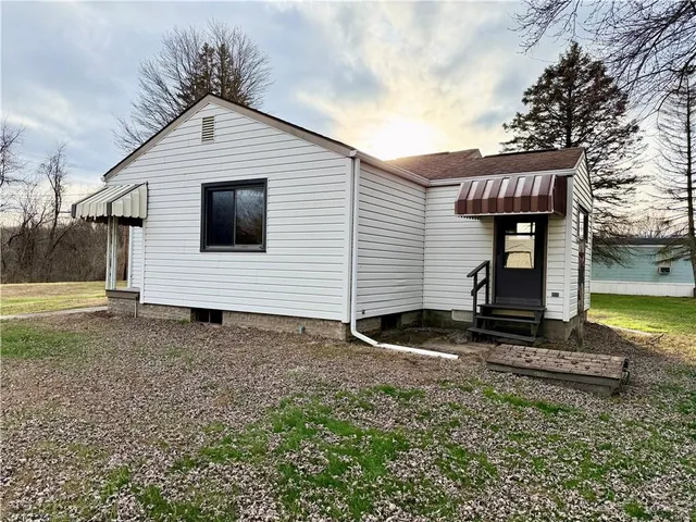 a view of a house with backyard and trees