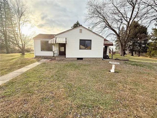a white house that has a tree in front of it
