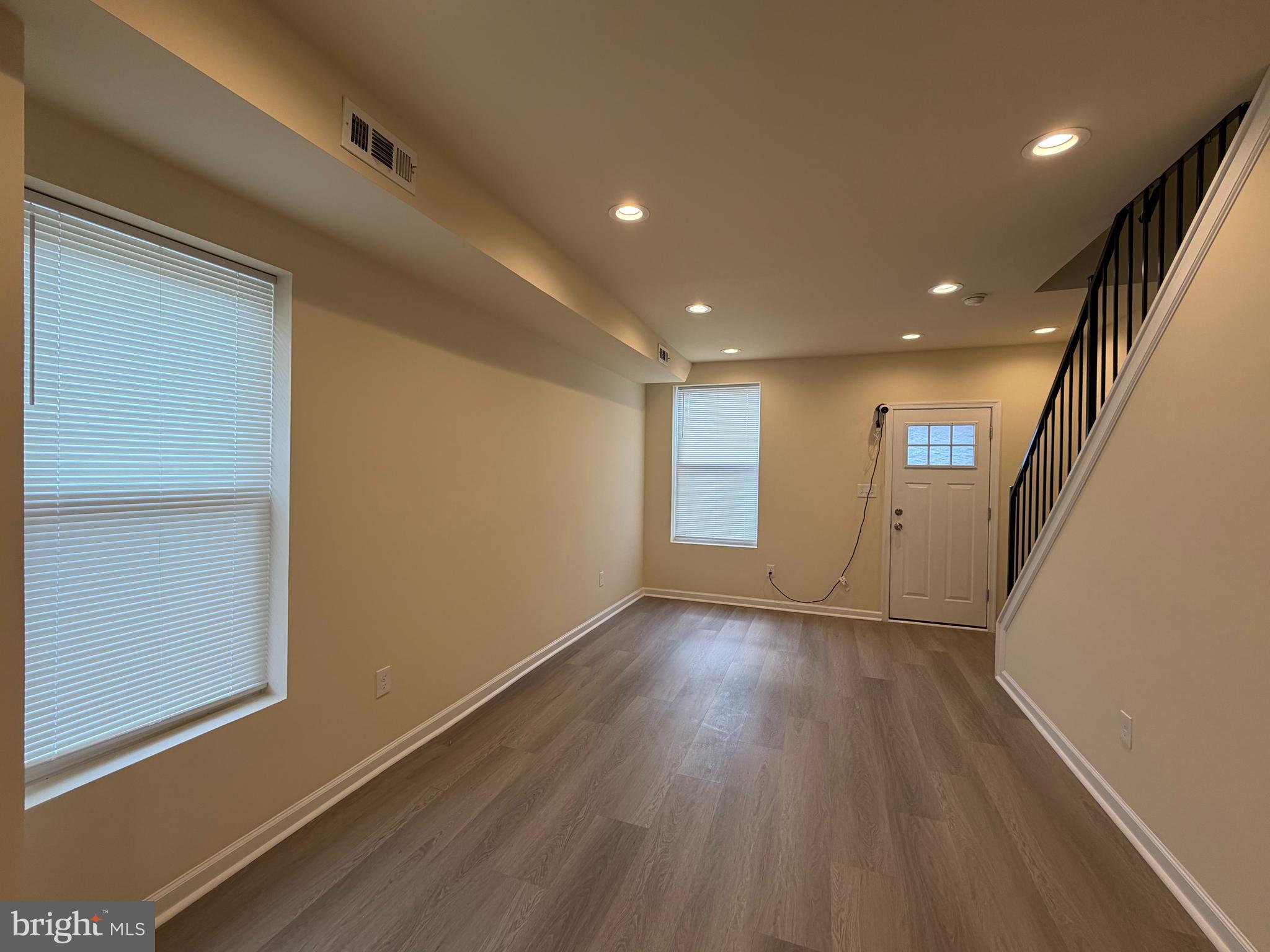 601 North Clinton Street Baltimore, MD 21205 - Photo 3 of 12 an empty room with wooden floor and windows