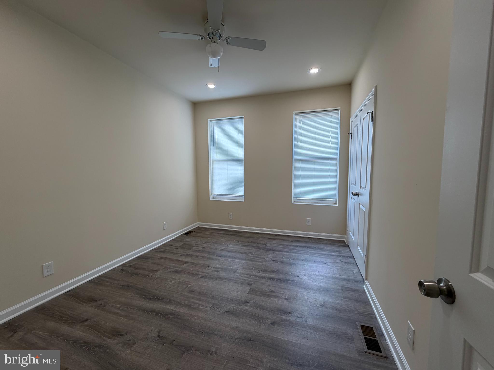 601 North Clinton Street Baltimore, MD 21205 - Photo 8 of 12 an empty room with wooden floor and a ceiling fan