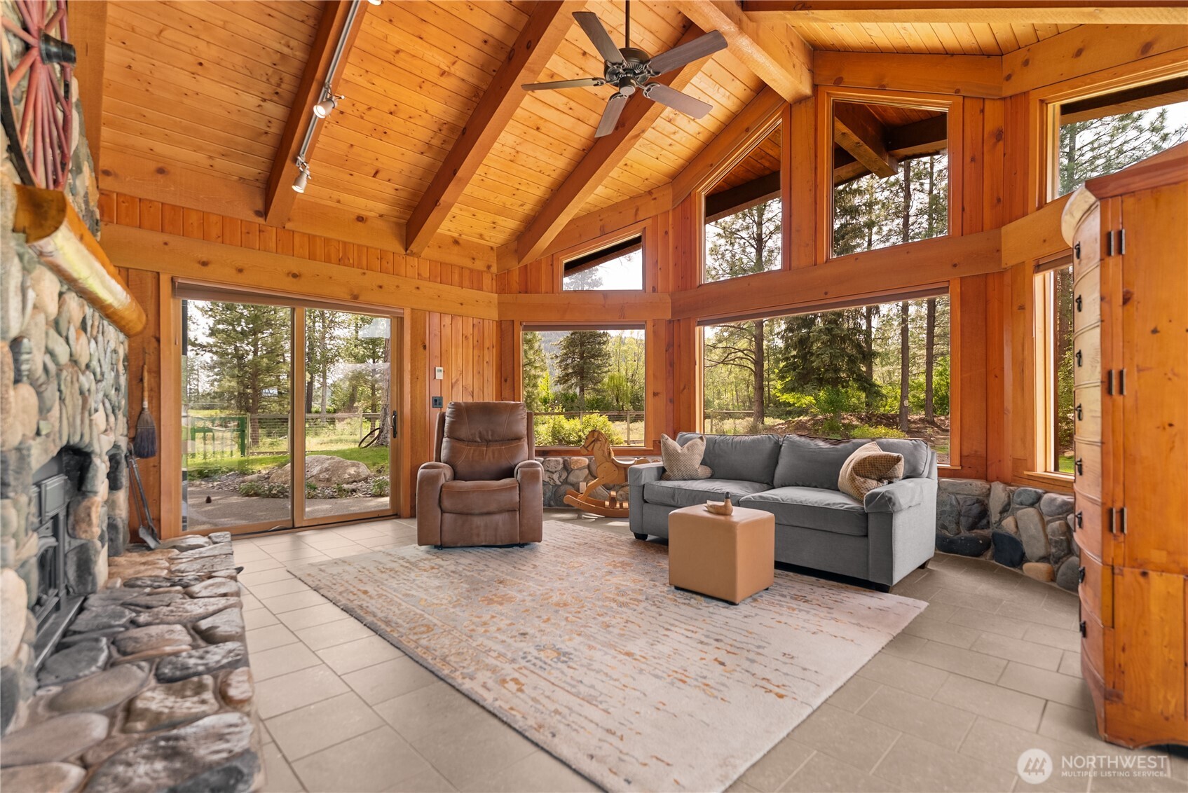 179 Wolf Creek Road Winthrop, WA 98862 - Photo 19 of 40 a living room with furniture tv and a floor to ceiling window