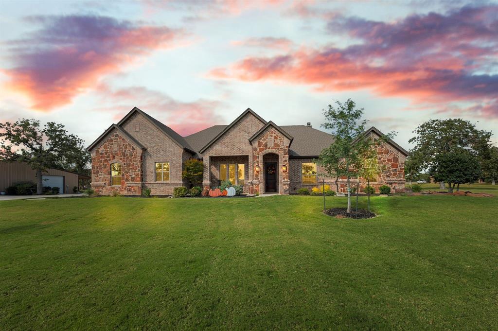 141 Mission Oak Trail Decatur, TX 76234 - Photo 1 of 1 French country inspired facade featuring stone siding, a front lawn, and brick siding