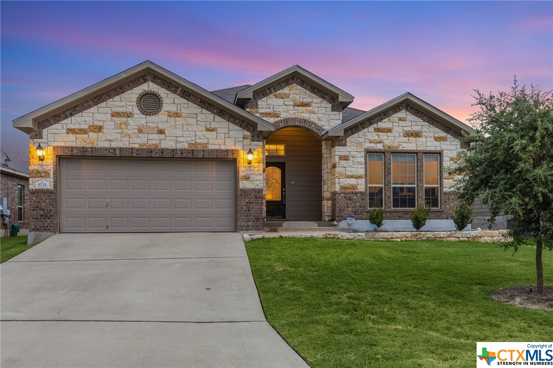 a front view of a house with a garden and plants
