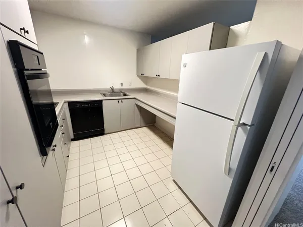 a white refrigerator freezer and a stove sitting inside of a kitchen