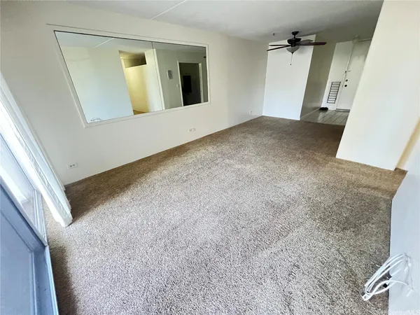 a view of a hallway with wooden floor and cabinet