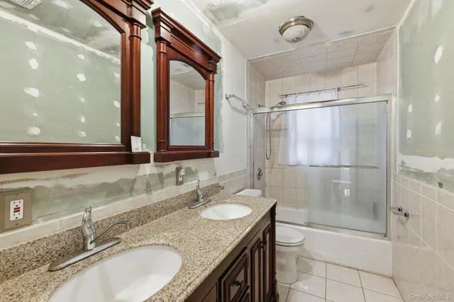 a bathroom with a granite countertop sink mirror and shower