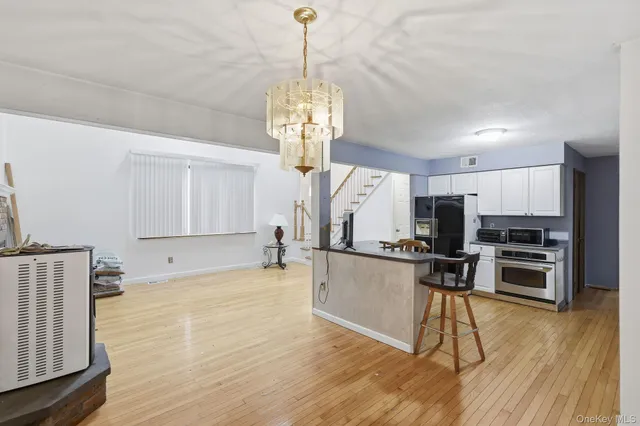 a kitchen with stainless steel appliances a kitchen island hardwood floor and a sink