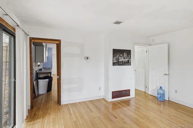a view of a hallway with wooden floor and closet