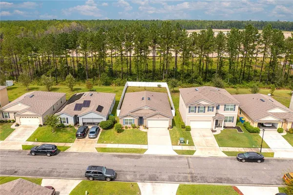 an aerial view of residential houses with outdoor space and swimming pool