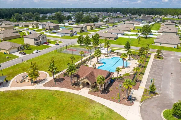 an aerial view of a swimming pool with outdoor seating