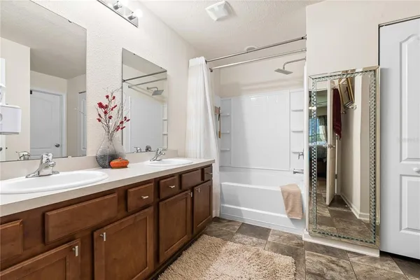 a spacious bathroom with a double vanity sink mirror double shower and a bathtub