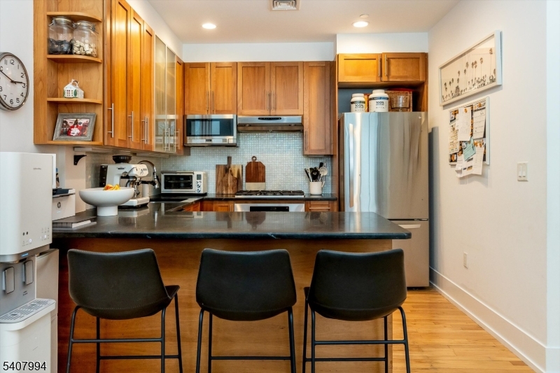 85 Park Avenue, Unit 205 Glen Ridge, NJ 07028 - Photo 16 of 37 a kitchen with stainless steel appliances granite countertop a refrigerator and a stove top oven