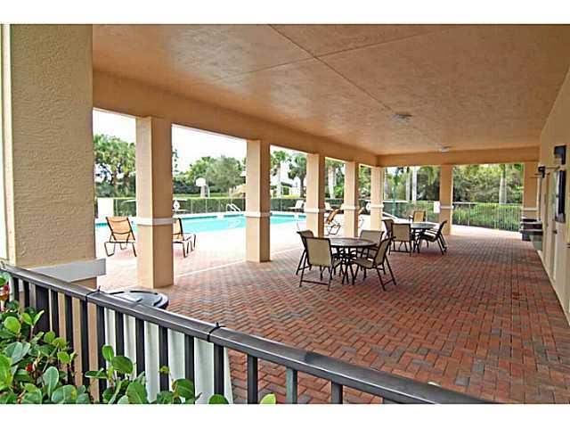 43 Southwest Squirrel Nest Way Stuart, FL 34997 - Photo 20 of 22 a view of a patio with table and chairs potted plants with wooden floor