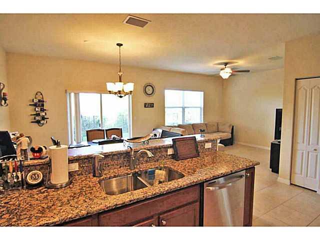 43 Southwest Squirrel Nest Way Stuart, FL 34997 - Photo 10 of 22 a kitchen with granite countertop a sink a stove and a wooden floor