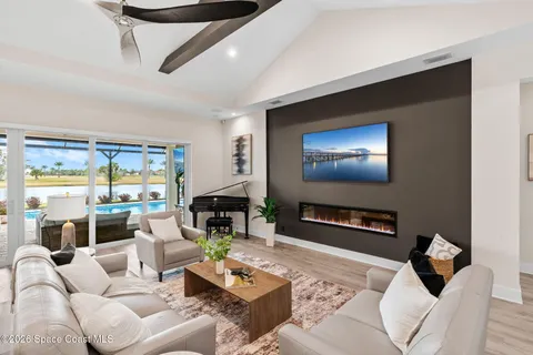 a living room with furniture flat screen tv and wooden floor