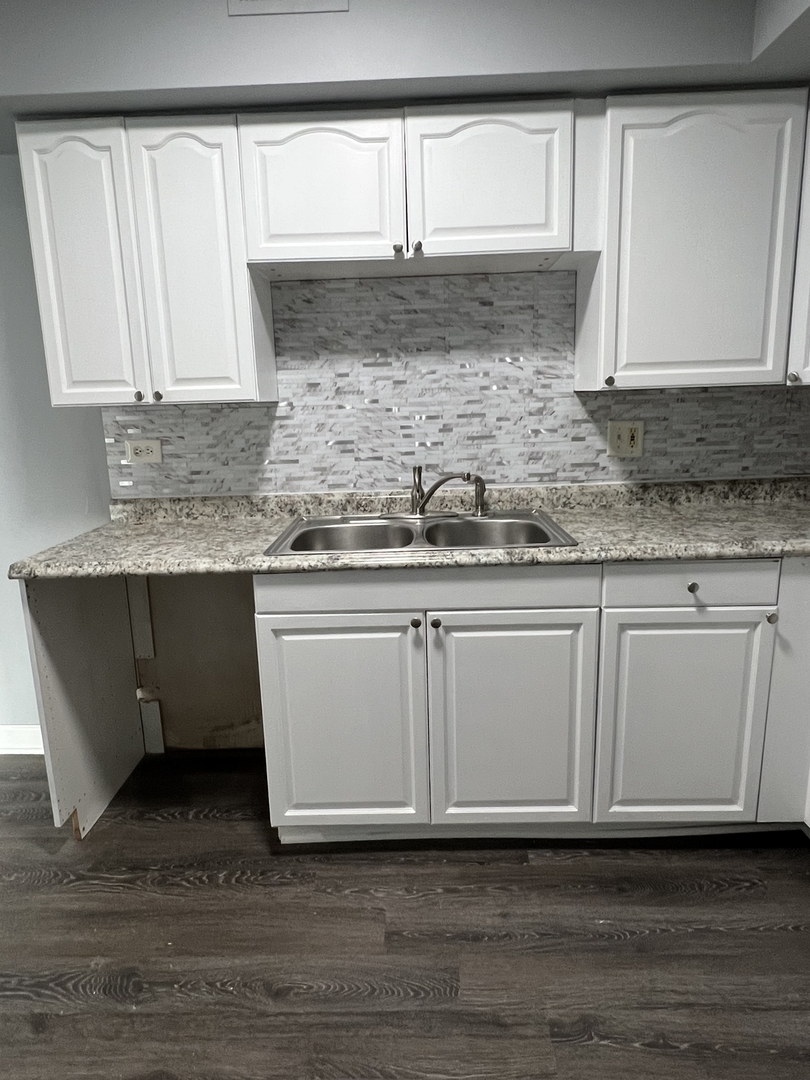 787 Wilson Avenue, Unit 10 Glen Ellyn, IL 60137 - Photo 11 of 26 a kitchen with granite countertop white cabinets and a sink
